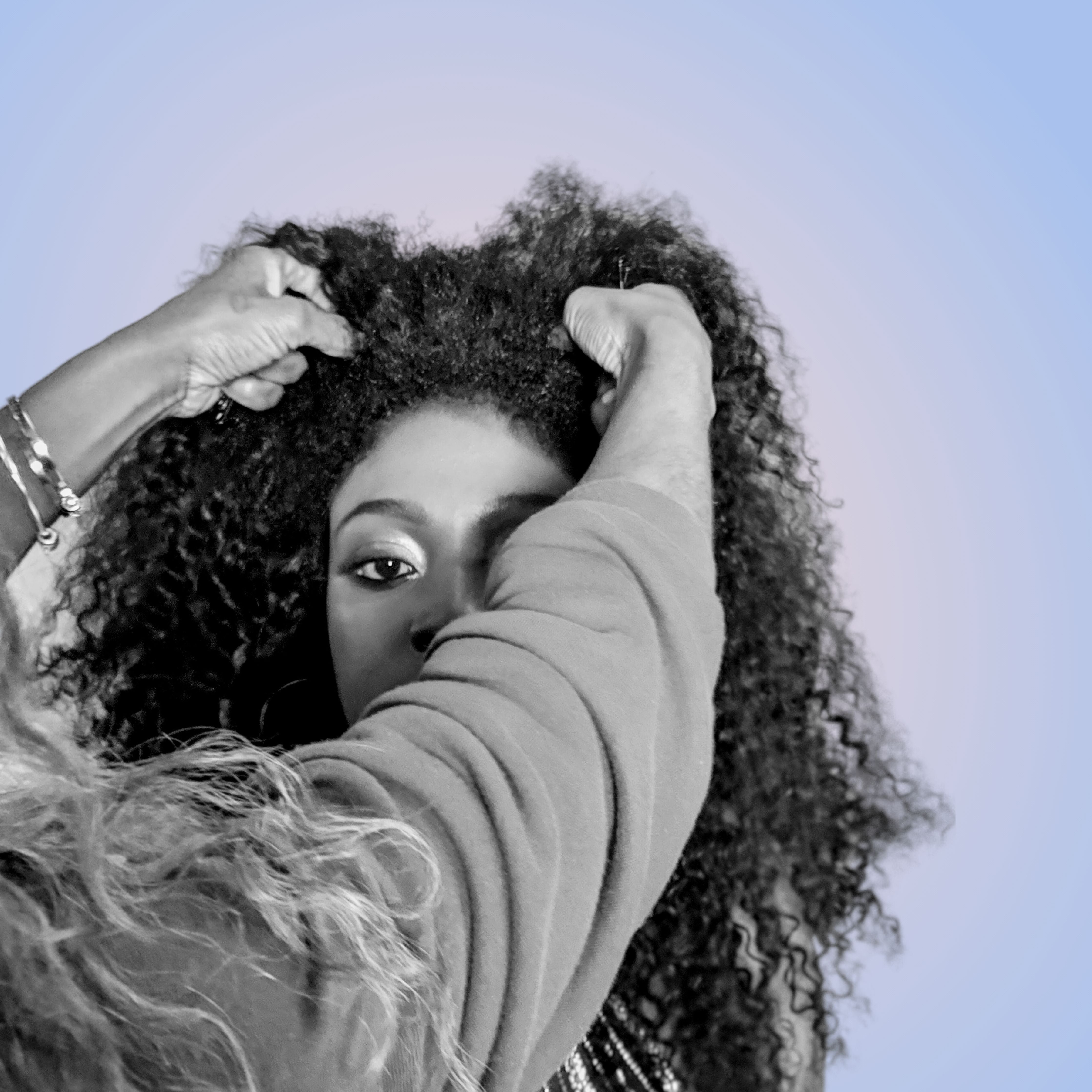 Women placing wig on another womens' head